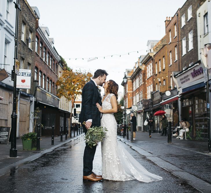 Bride and groom at London wedding with white foliage bouquet