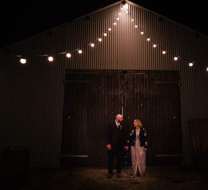 Bride in Sequinned Kimono from ASOS | Groom in Burgundy Tweed Three Piece Suit | Edison Bulb Floral Installation at Kingsthorpe Lodge Barn Wedding | Johnny Dent Photography