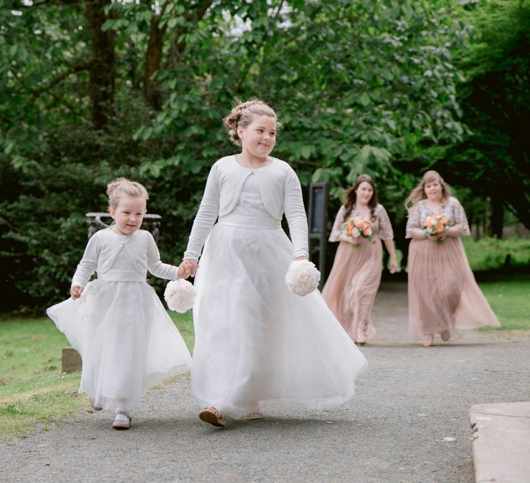 Flower girls and bridesmaids make their way to wedding ceremony