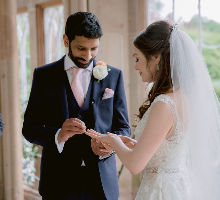 Bride and groom exchange rings during ceremony