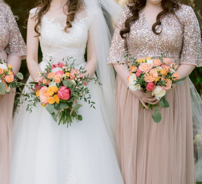 Pink bridesmaid dresses with bright peony bouquets