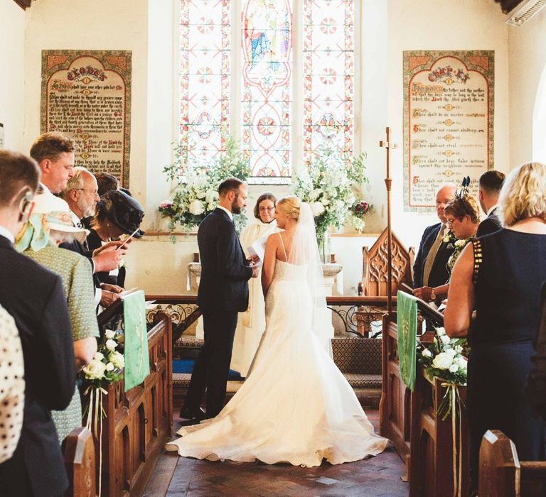 Wedding Ceremony | Bride in Essense of Australia Dress with Spaghetti Straps and Fishtail | Floor Length Veil | Groom in Blue Suit with White and Green Buttonhole | Quintessential English Country Wedding in Glass Marquee at Family Home | Maryanne Weddings Photography