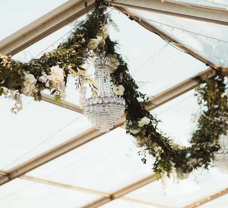 Glass Marquee | Hanging Garland with White Flowers and Greenery | Glass Chandeliers | Fairy Lights | Quintessential English Country Wedding in Glass Marquee at Family Home | Maryanne Weddings Photography