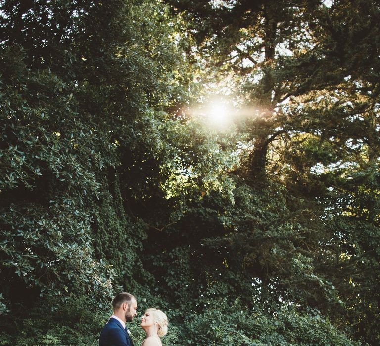 Bride in Essense of Australia Dress with Spaghetti Straps and Fishtail | Groom in Blue Suit with White and Green Buttonhole | Quintessential English Country Wedding in Glass Marquee at Family Home | Maryanne Weddings Photography