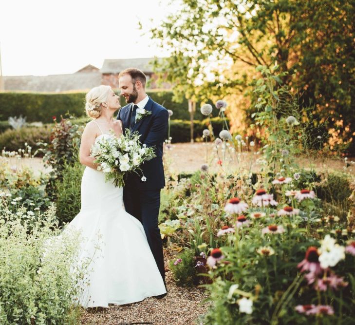 Bride in Essense of Australia Dress with Spaghetti Straps and Fishtail | Groom in Blue Suit with White and Green Buttonhole | Bridal Bouquet of White Flowers and Greenery | Quintessential English Country Wedding in Glass Marquee at Family Home | Maryanne Weddings Photography