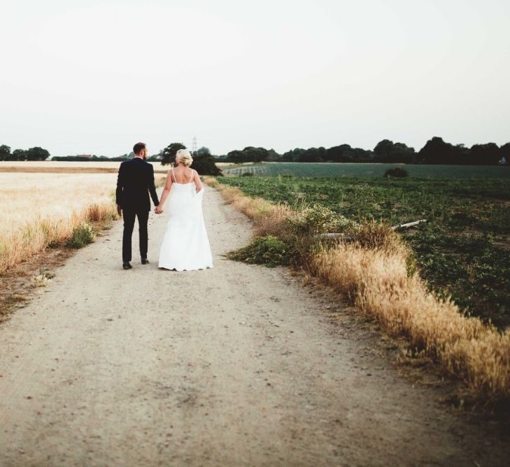 Bride in Essense of Australia Dress with Spaghetti Straps and Fishtail | Groom in Blue Suit with White and Green Buttonhole | Quintessential English Country Wedding in Glass Marquee at Family Home | Maryanne Weddings Photography