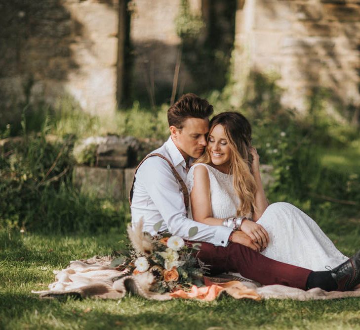 Boho Bride and Groom Sitting on a Rug in The Sun