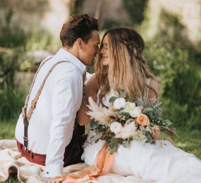 Boho Bride and Groom Kissing on a Picnic Blanket