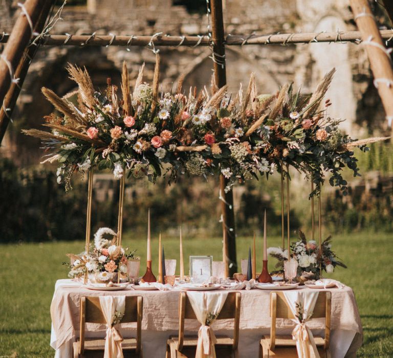 Outdoor Tablescape with Floral Installation Under a Naked Tipi