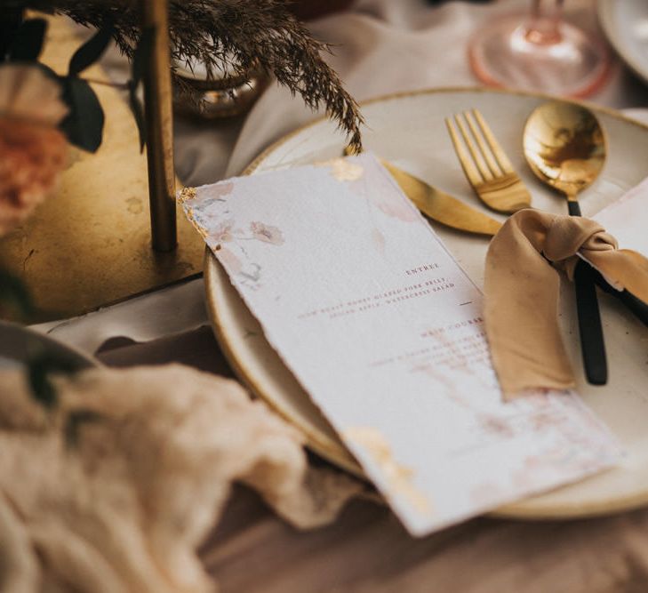 Place Setting with Gold and Black Cutlery Tied with Ribbon and Menu Cards