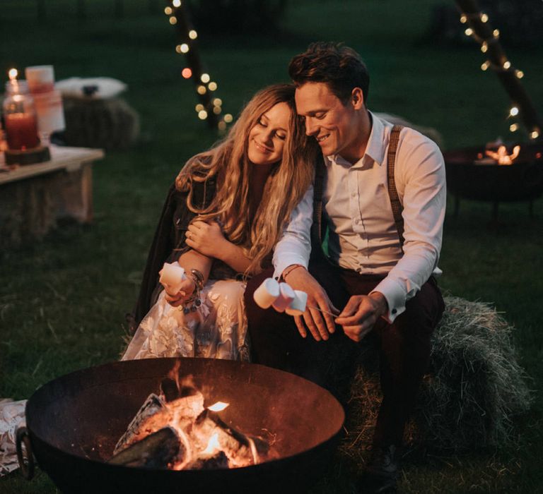 Boho Bride and Groom Embracing a Smoke Pit Toasting Marshmallows