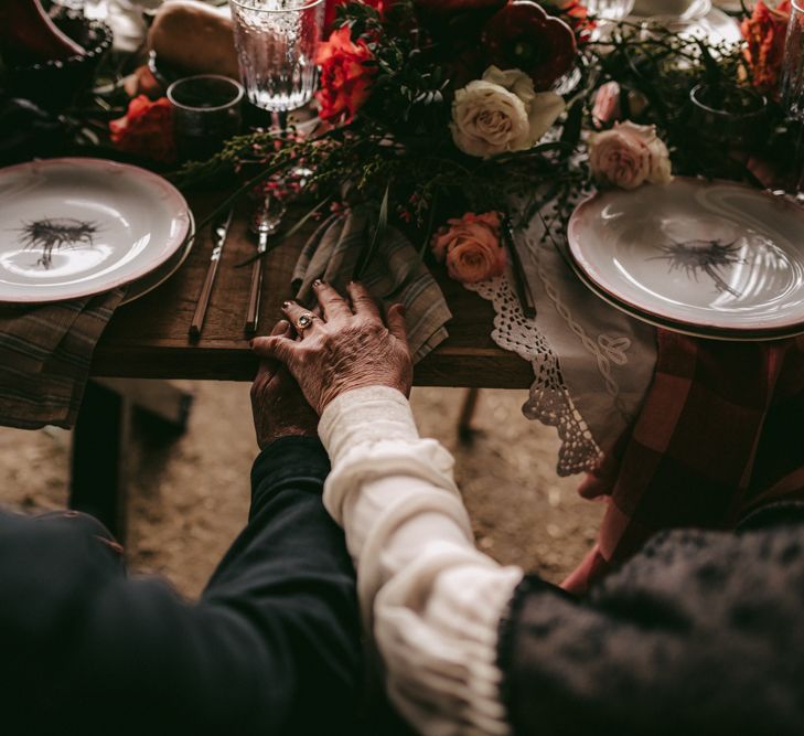 Couple holding hands at intimate tablescape