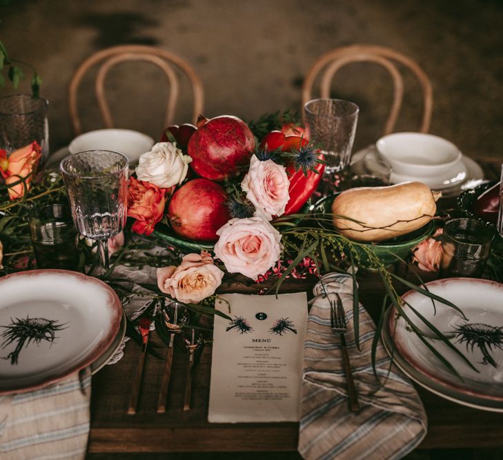 Place settings with patterned tableware and fruit centrepieces