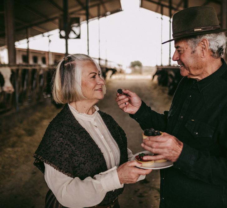 Couple feeding each other berries at golden wedding anniversary