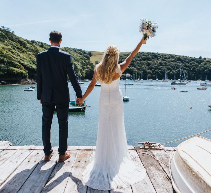 Bride in Sophia Tolli Galene Wedding Dress and Groom in Navy Blue Ted Baker Suit Celebrating by by the Dock