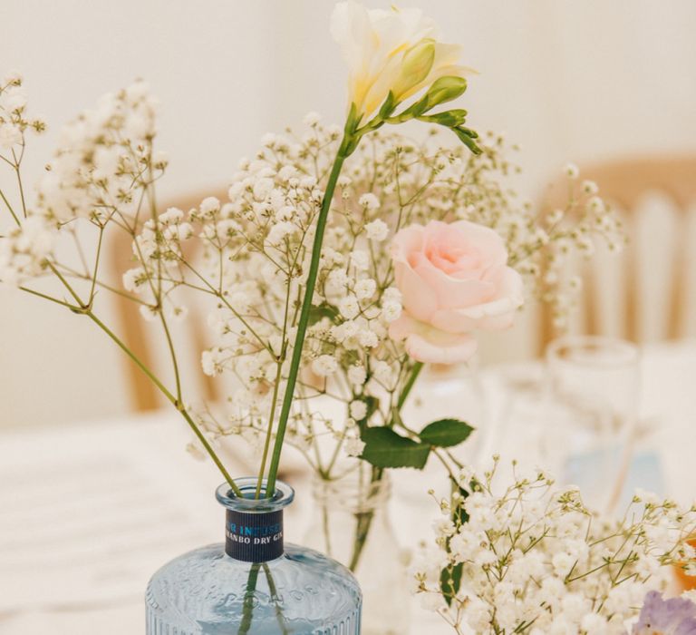 Gin Bottles Filled with Flower Stems as Centrepieces