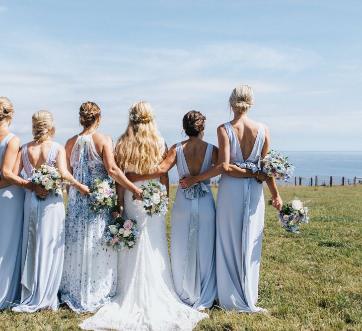 Bridal Party Portrait with Maid of Honour in Halterneck Floral Dress, Bridesmaids in Pale Blue Dresses with Bow Back and Bride in Sophia Tolli Wedding Dress