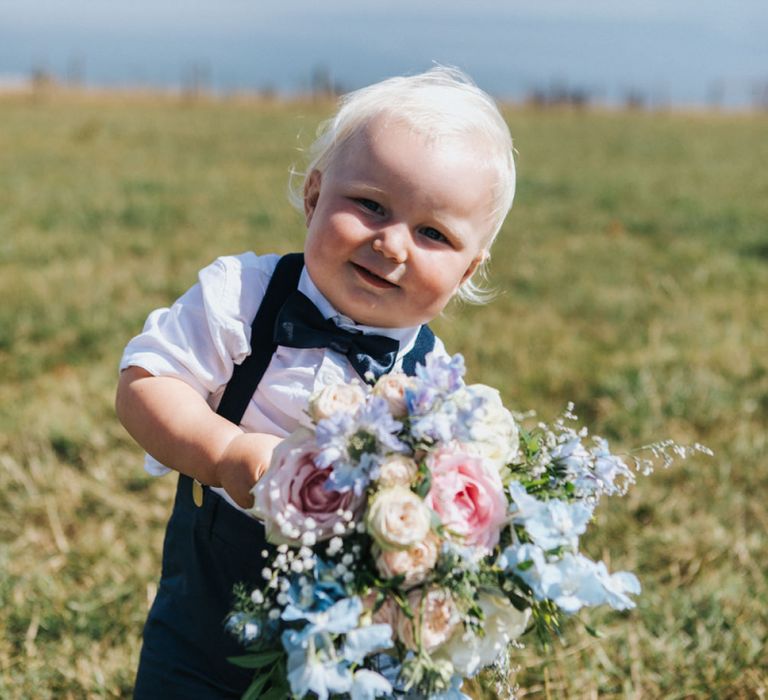 Cute Page Boy in Bow Tie and Braces Holding a Pastel Pink and Blue Wedding Bouquet