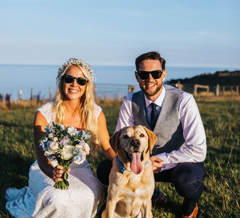 Bride in Sophia Tolli Wedding Dress and Groom in Grey Waistcoat Posing with Their Pet Dog