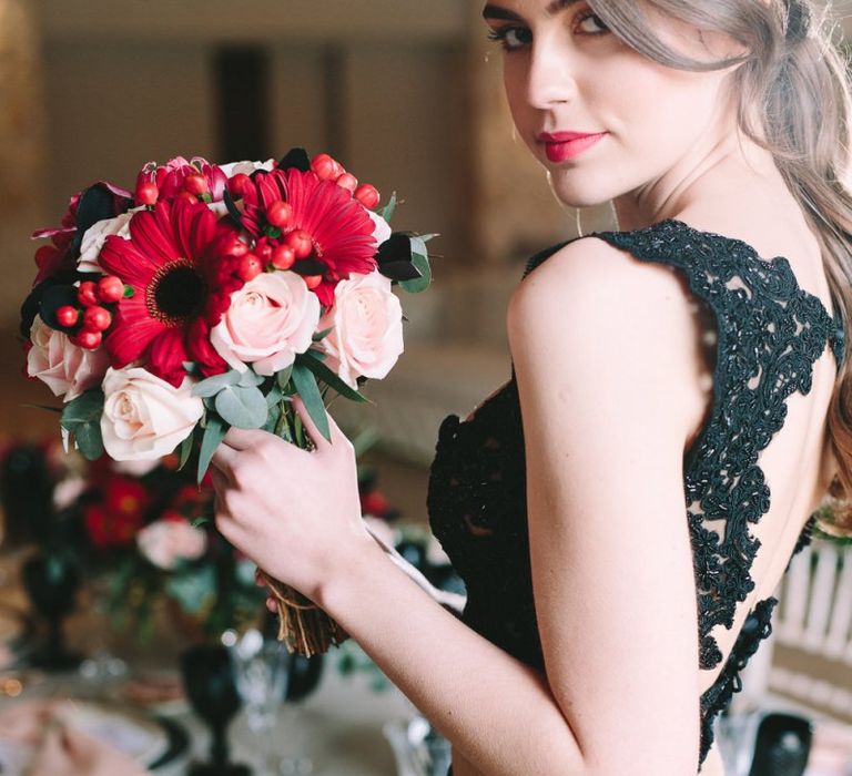 Bride in Black Skirt and Lace Top Holding a Pink and Red Bouquet