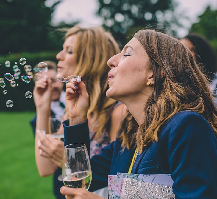 Bubbles for Guests. A Quintessentially British Venue at Cambridge Cottage, Royal Botanic Gardens Kew. Bride Wears Paloma Blanca from Pure Couture Bridal and Groom Wears Tailored Suit from Hackett London.