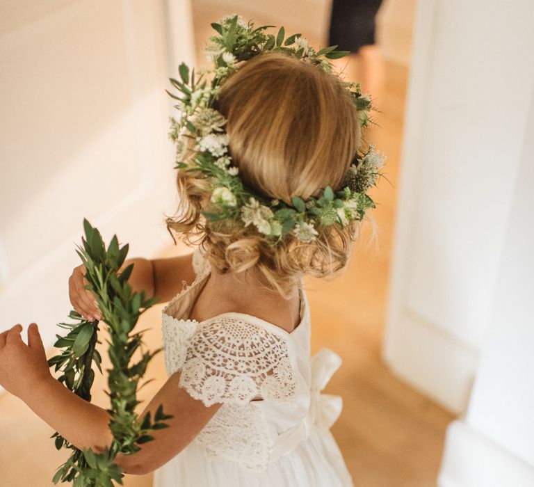 Flower girl in white dress with green crown