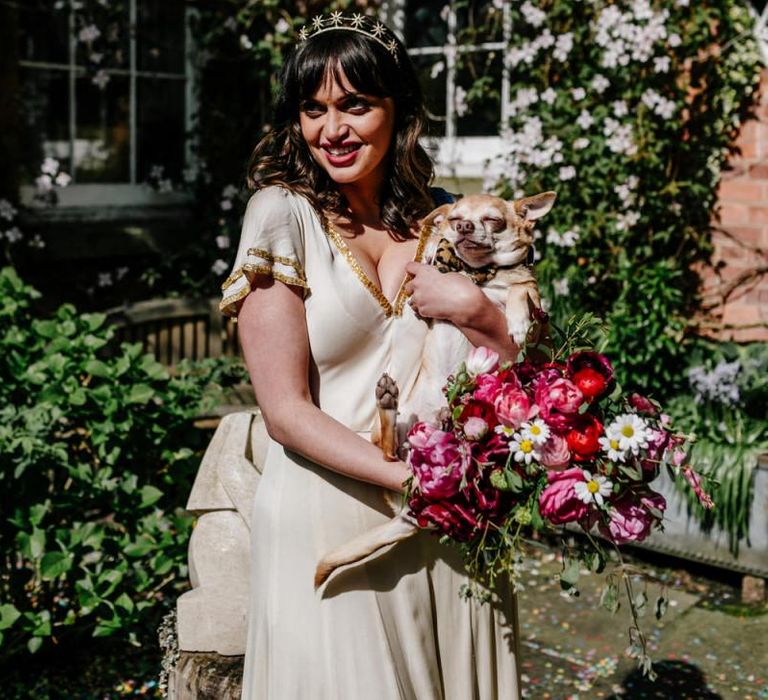 RockNRoll Bride in Vintage Wedding Dress with Gold Trim Holding Her Pet Dog