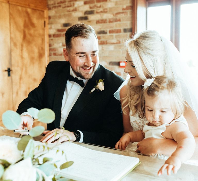 Bride and groom with daughter at wedding ceremony