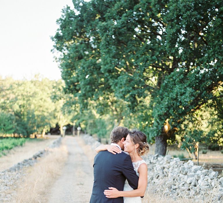 Elegant Bride in Lace Wedding Dress | Groom in Black Tie Suit | Outdoor Wedding at Commanderie de Peyrassol, Provence, France Styled by La Chuchoteuse | Lace Bridal Gown | Black Tie Suit | Rustic Stretch Tent Reception | Raisa Zwart Photography