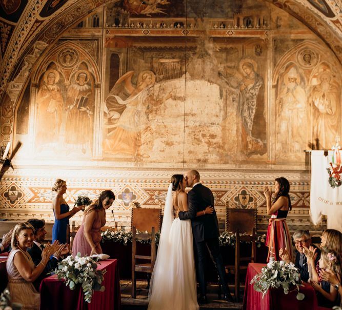 Bride in Justin Alexander wedding dress with groom during ceremony