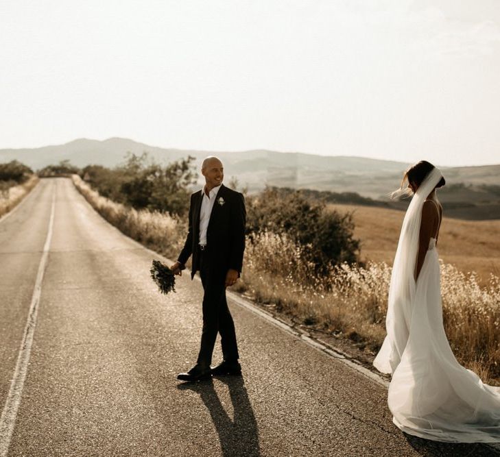 Bride wears Justin Alexander wedding dress with groom in black suit