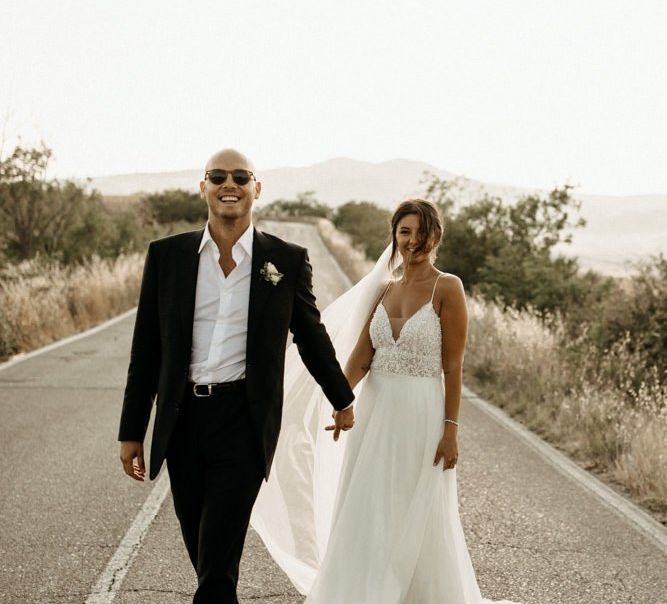 Bride wears Justin Alexander wedding dress with groom in black suit