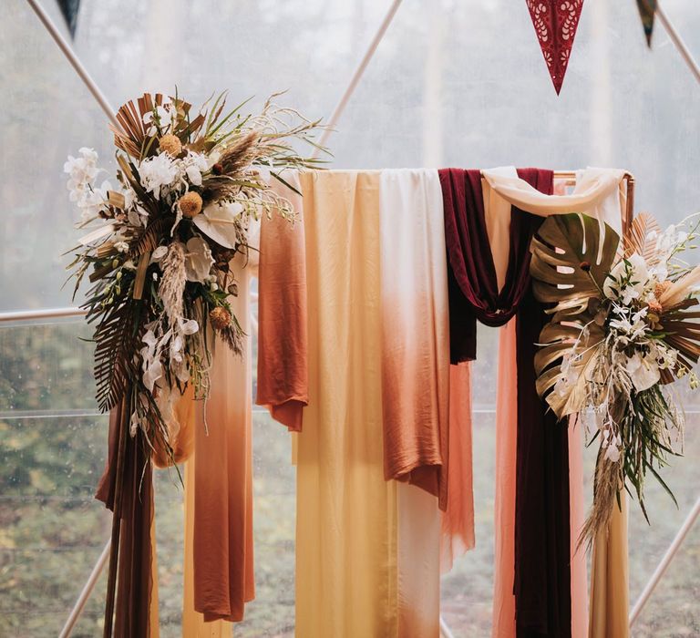 Wedding Altar Decor Covered in Drapes and Boho Flowers in Geometric Dome