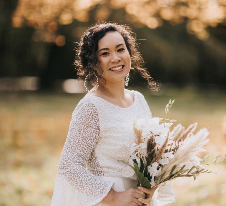 Bride in Rolling in Roses Wedding Dress Holding a Boho Bouquet