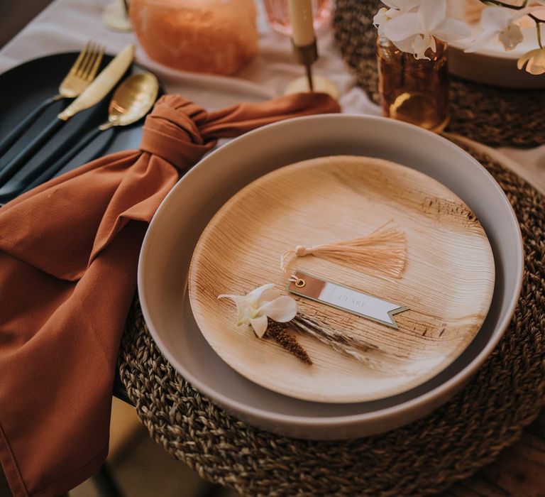 Place Setting with Terracotta and Wood Plates on Wicker Place Mats