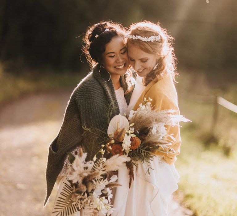 Same Sex Brides Embracing During Golden Hour