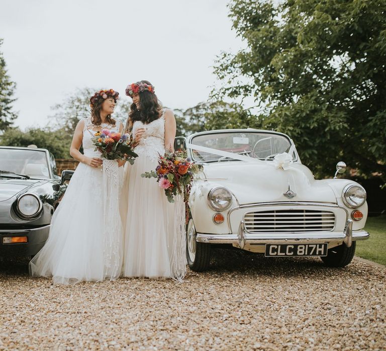 Two Brides in Lace Wedding Dress with Tulle Skirts Standing Next to Their Wedding Cars