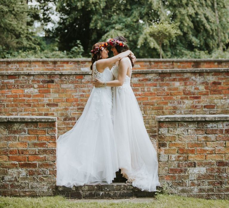 Two Brides in Lace Wedding Dresses Embracing