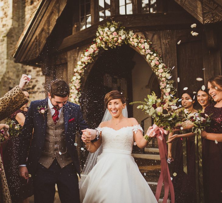 Church Confetti Moment | Bride in Lillian West Bridal Separates | Groom in Navy Suit &amp; Tweed Waistcoat | Burgundy &amp; Gold Winter Wedding at Ramster Hall Weddings, Surrey | Matt Penberthy Photography | John Harris Wedding Films