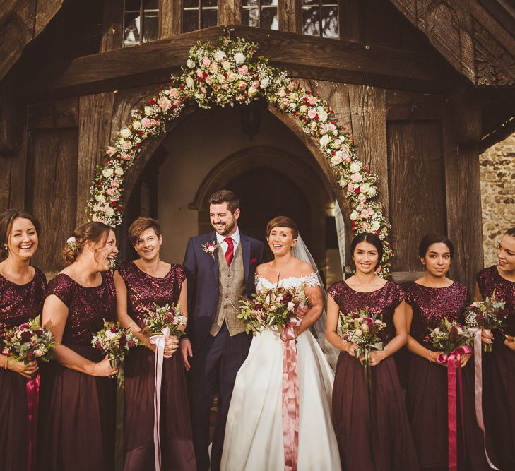 Church Floral Arch Wedding Flowers | Bride in Lillian West Bridal Separates | Bridesmaids in Burgundy Coast Sequin Top &amp; High Low Skirt Separates | Groom in Navy Suit &amp; Tweed Waistcoat | Burgundy &amp; Gold Winter Wedding at Ramster Hall Weddings, Surrey | Matt Penberthy Photography | John Harris Wedding Films