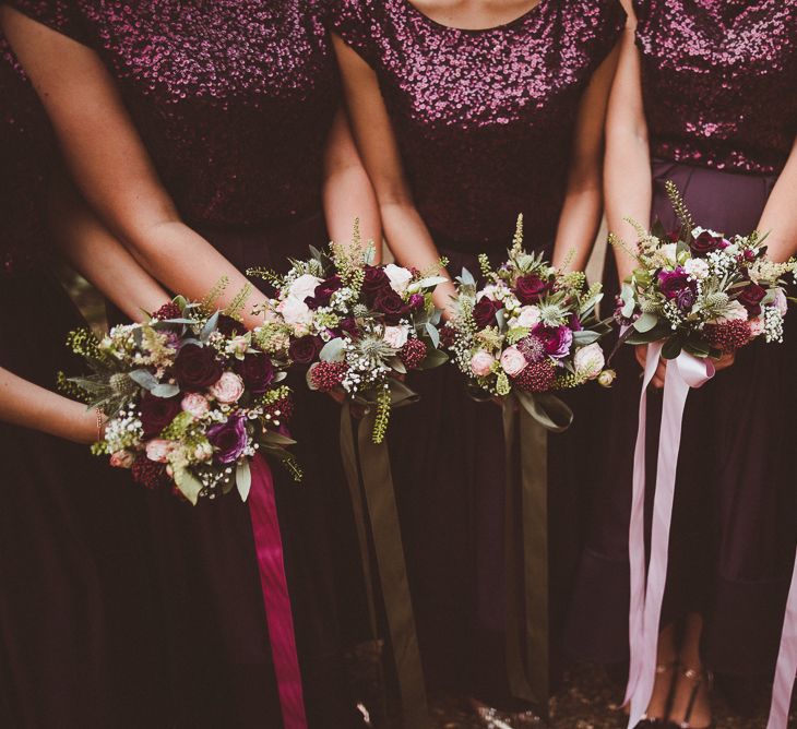 Bouquets with Ribbon | Bridesmaids in Coast Burgundy Separates | Sequin Tops &amp; High Low Skirts | Bride in Lillian West Bridal Separates | Burgundy &amp; Gold Winter Wedding at Ramster Hall Weddings, Surrey | Matt Penberthy Photography | John Harris Wedding Films