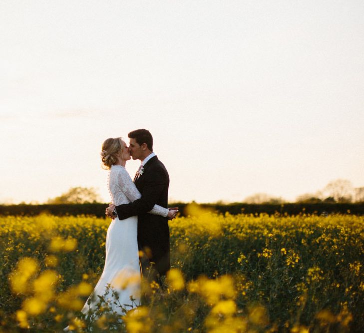 Yellow meadow couple shoot at dusk | Papakata Sperry Tent Wedding at family home | Sassi Holford Dress with added ivory Ostrich feathers to veil | Manolo Blahnik shoes | Images by Melissa Beattie