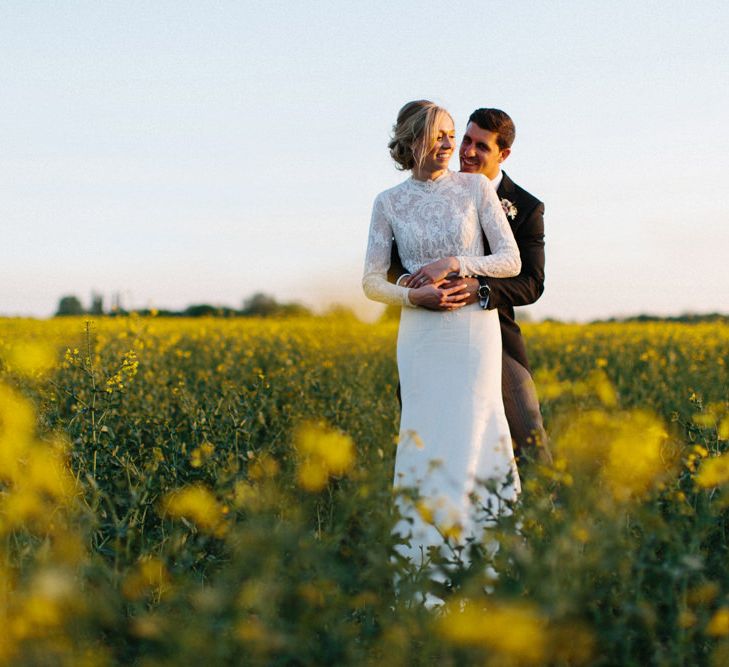 Yellow meadow couple shoot at dusk | Papakata Sperry Tent Wedding at family home | Sassi Holford Dress with added ivory Ostrich feathers to veil | Manolo Blahnik shoes | Images by Melissa Beattie