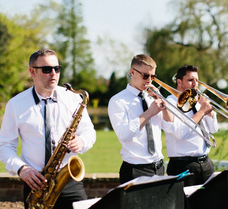 Roaming Band welcoming guests | Papakata Sperry Tent Wedding at family home | Sassi Holford Dress with added ivory Ostrich feathers to veil | Manolo Blahnik shoes | Images by Melissa Beattie