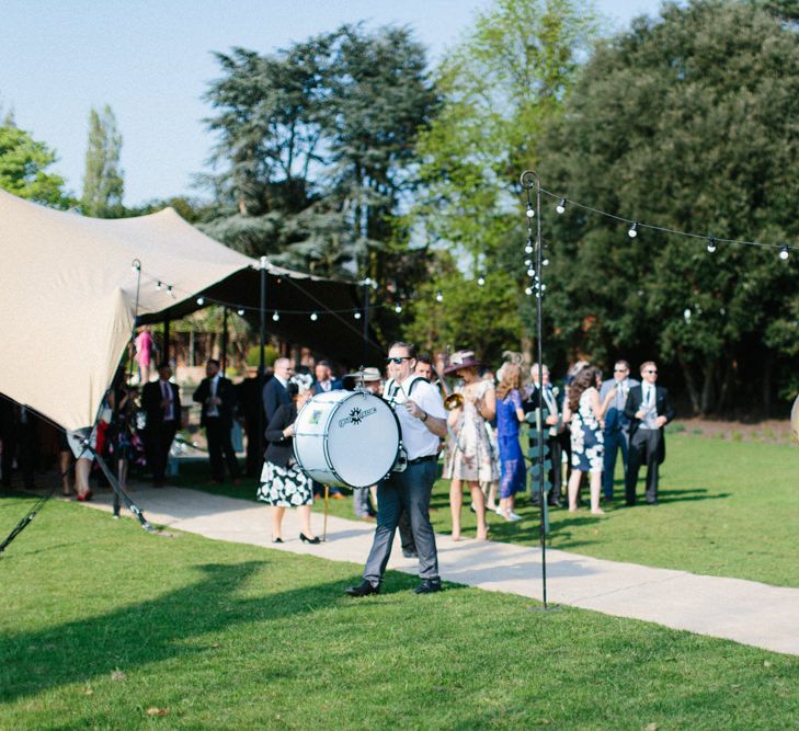 Roaming Band welcoming guests | Papakata Sperry Tent Wedding at family home | Sassi Holford Dress with added ivory Ostrich feathers to veil | Manolo Blahnik shoes | Images by Melissa Beattie