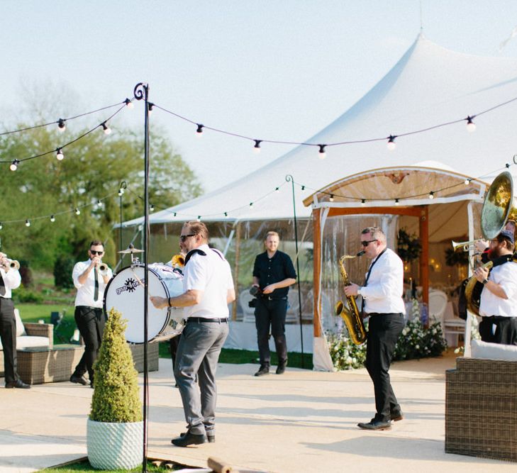 Roaming Band welcoming guests | Papakata Sperry Tent Wedding at family home | Sassi Holford Dress with added ivory Ostrich feathers to veil | Manolo Blahnik shoes | Images by Melissa Beattie