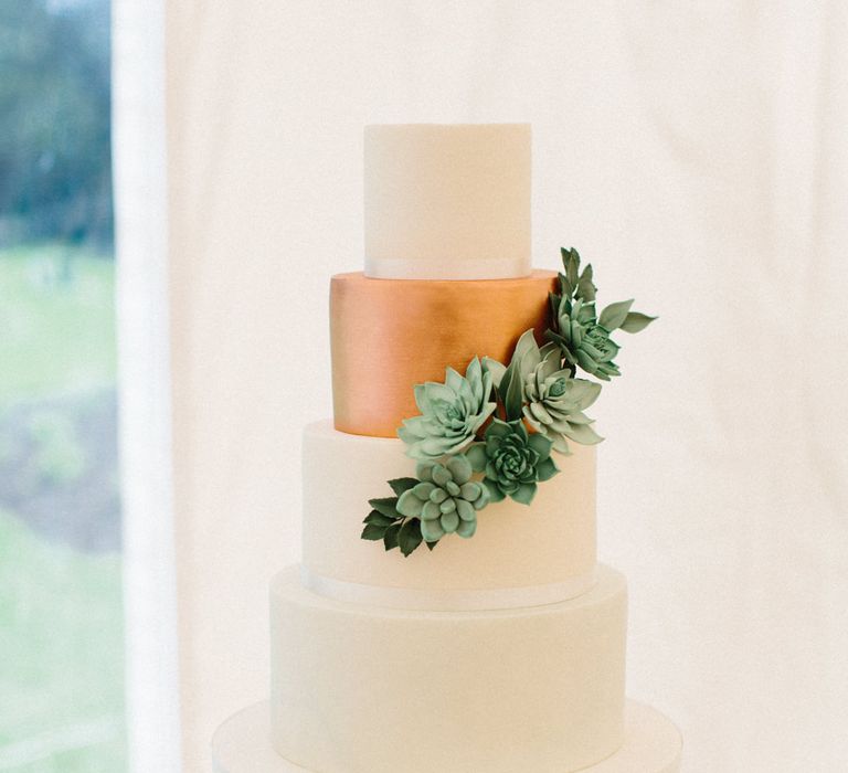 Simple elegant white cake with metallic layer and succulents | Papakata Sperry Tent Wedding at family home | Sassi Holford Dress with added ivory Ostrich feathers to veil | Manolo Blahnik shoes | Images by Melissa Beattie