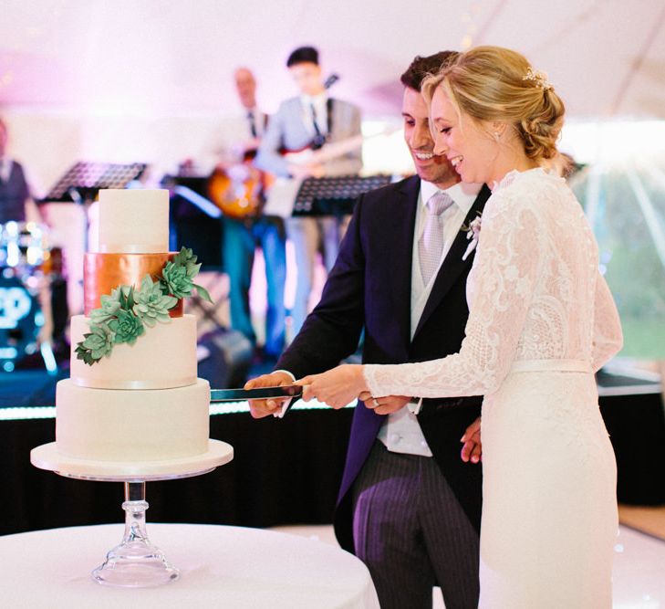 Simple elegant white cake with metallic layer and succulents | Papakata Sperry Tent Wedding at family home | Sassi Holford Dress with added ivory Ostrich feathers to veil | Manolo Blahnik shoes | Images by Melissa Beattie