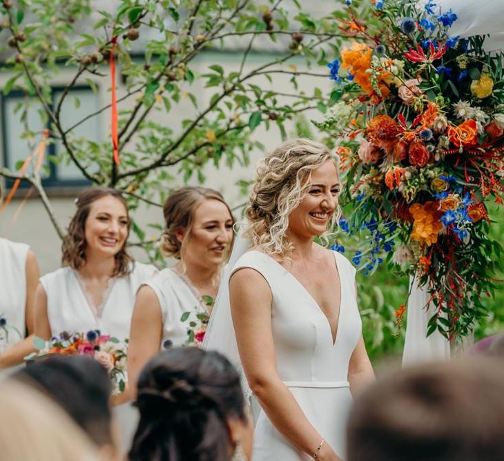 Bridal party at outdoor ceremony with bright wedding decorations