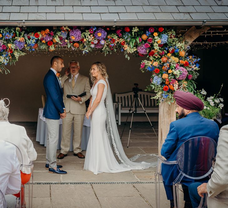 Outdoor ceremony with bright wedding decorations and stunning colourful flowers